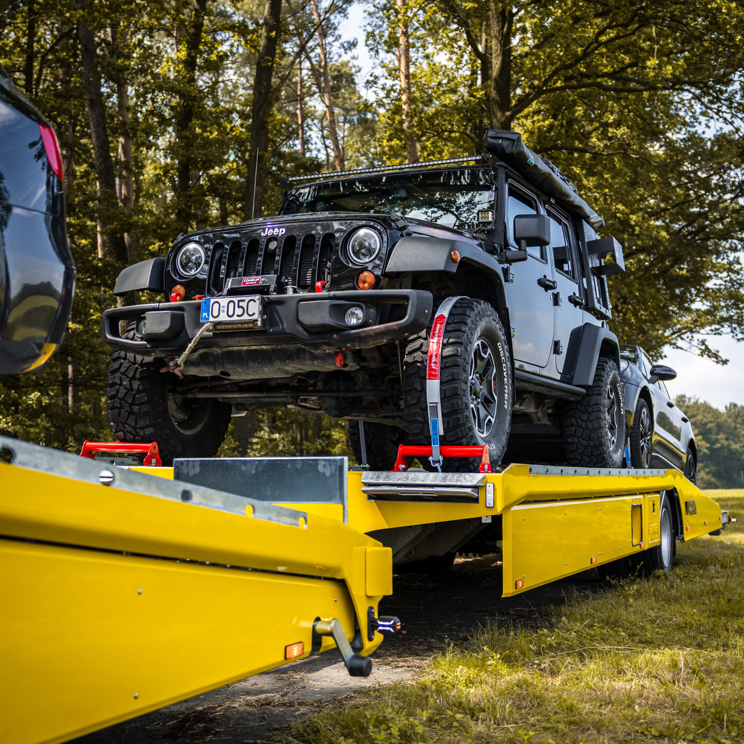Jeep na lawecie żółtej zabudowy specjalistycznej transportowej