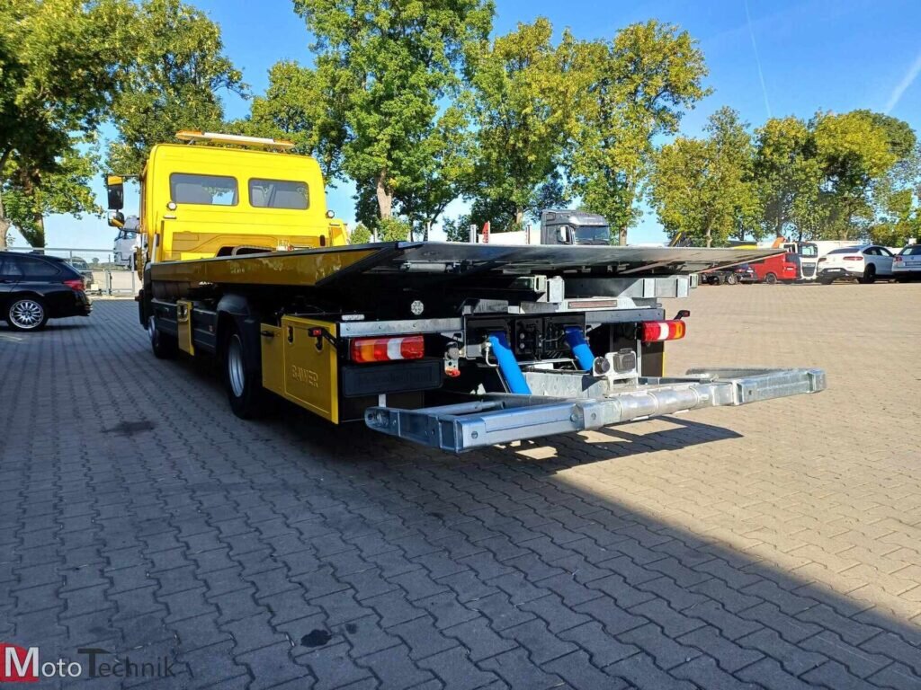 żółta laweta Mercedes Atego platforma hydrauliczna na placu
