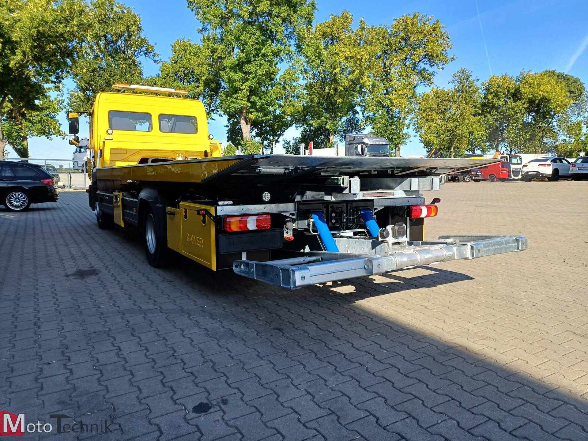 żółta laweta Mercedes Atego platforma hydrauliczna na placu