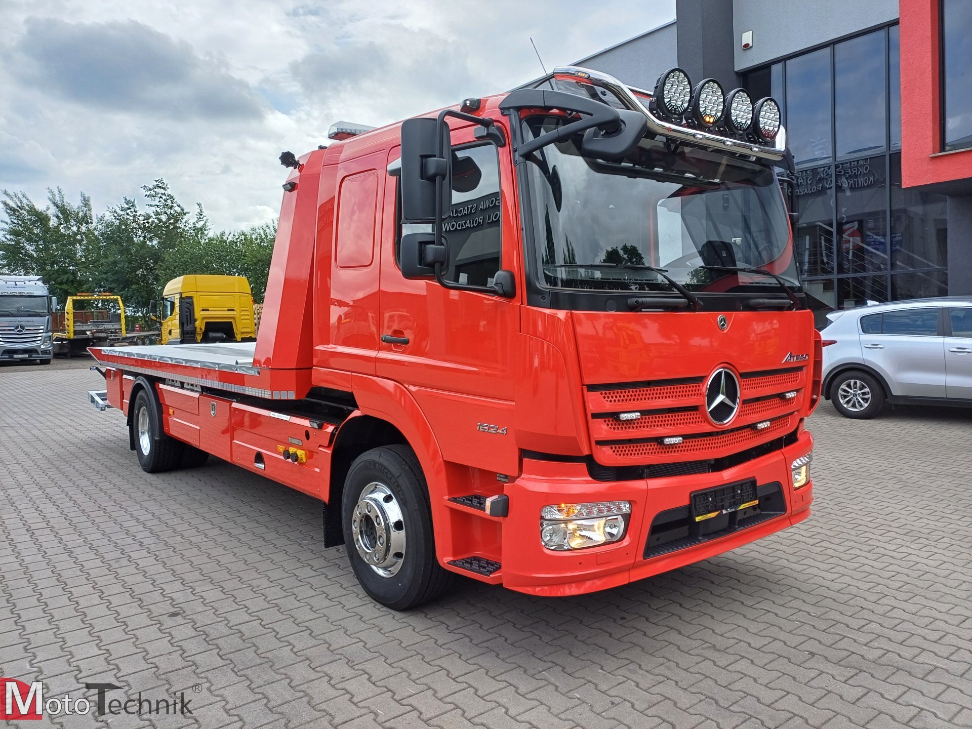 Czerwony Mercedes Atego 1624 z platformą hydrauliczną holownik