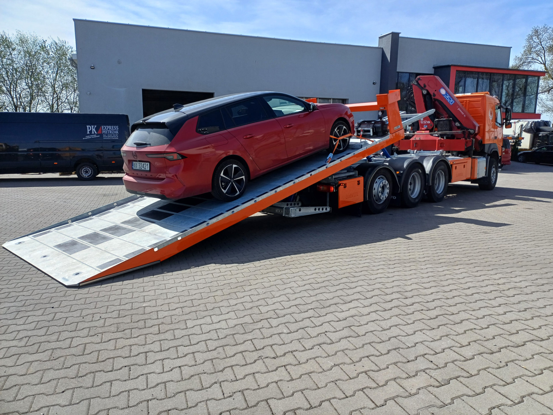 Volvo FM 450 laweta z platformą hydrauliczną i samochodem Opel