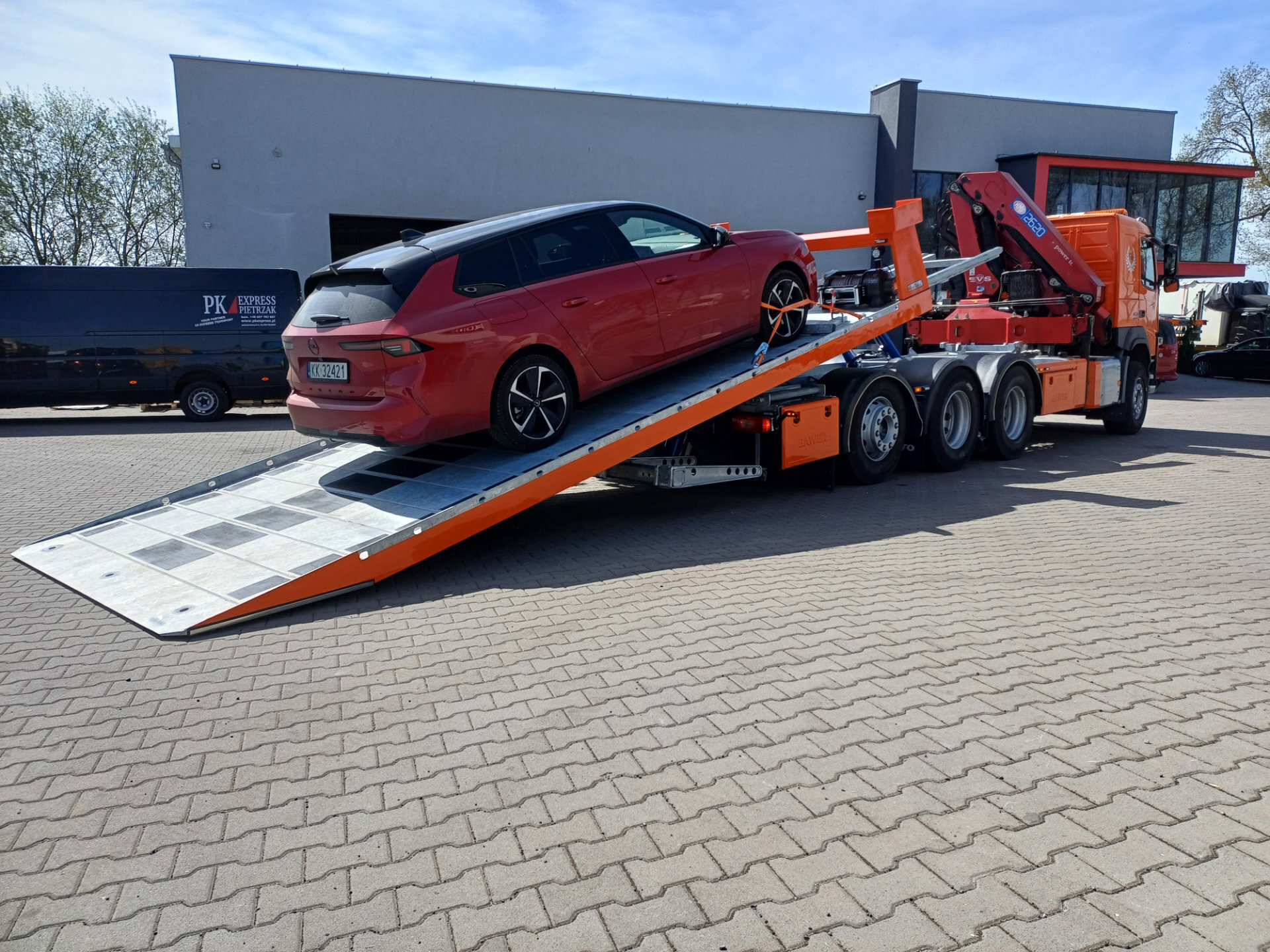 Samochód na platformie hydraulicznej przy budynku w Krakowie
