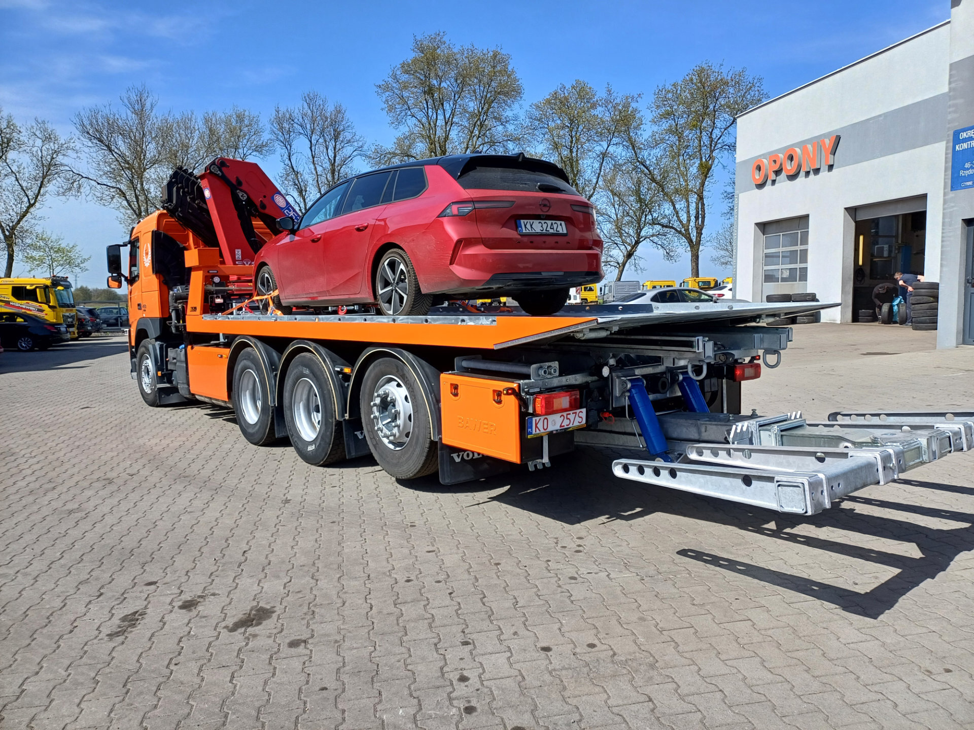 Pomarańczowy samochód ciężarowy z czerwoną osobową na platformie