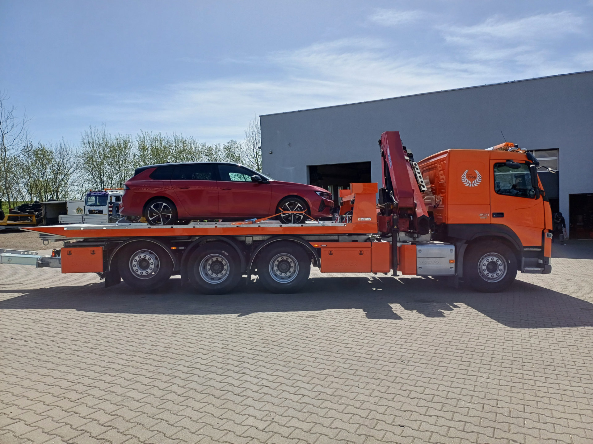 Pomarańczowy samochód Volvo z czerwoną osobową na lawecie