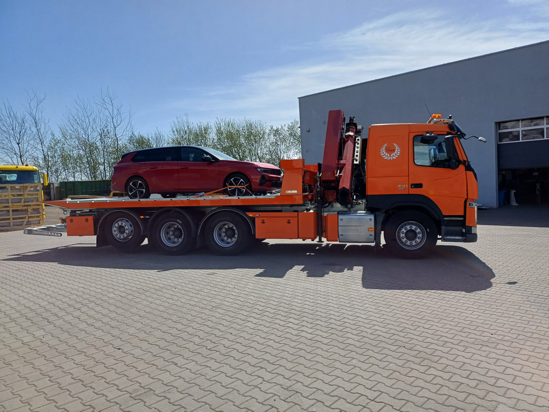 ciężarówka Volvo FM 450 z platformą hydrauliczną i samochodem