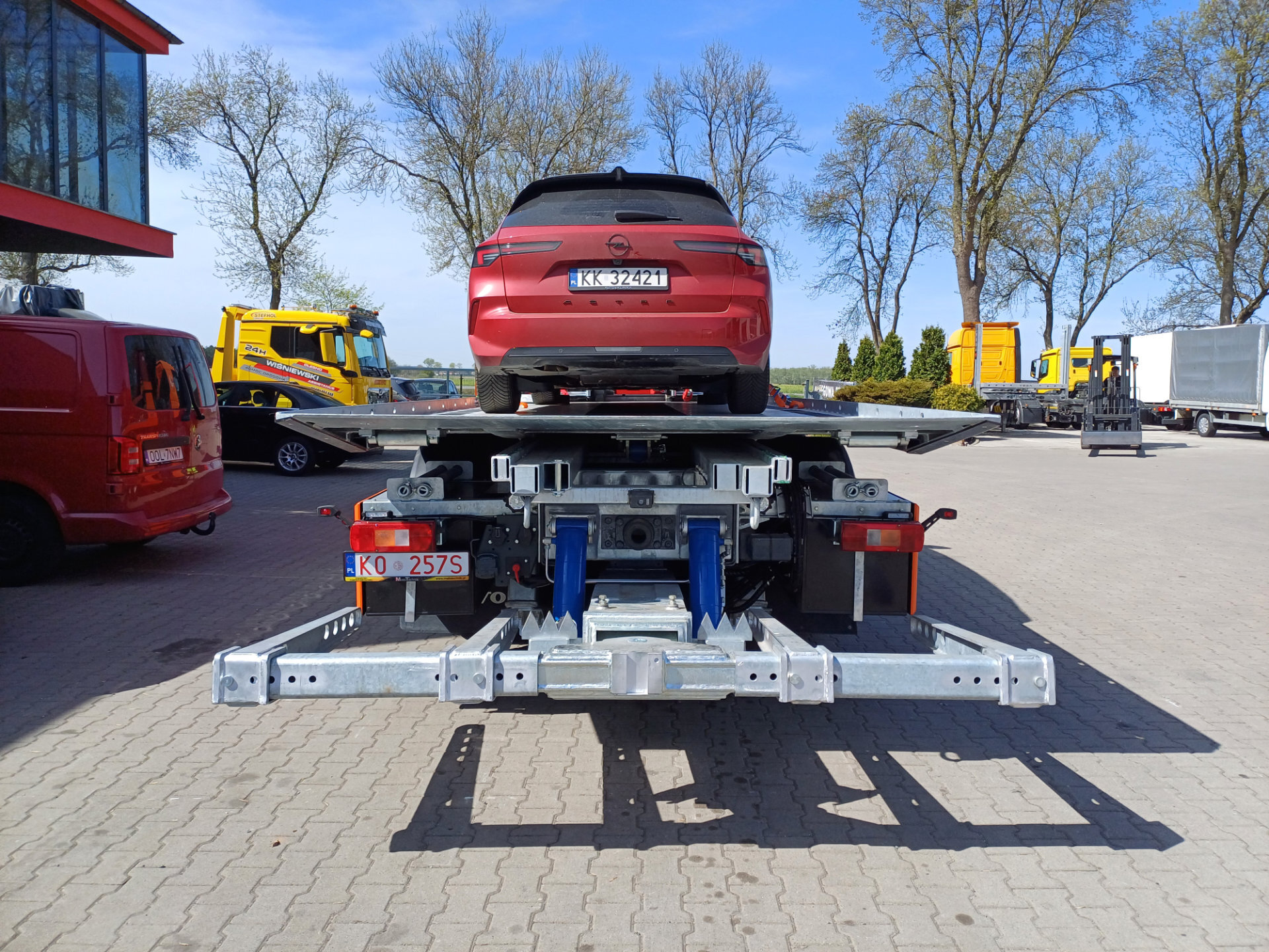 Czerwony samochód na platformie hydraulicznej lawety Volvo FM 450